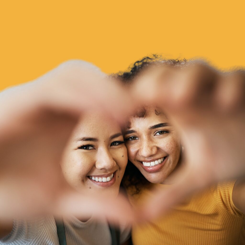 Relationship Reset - women hand heart Close up fun portrait of happy multiracial couple doing piggybacking outdoors. Black man carrying caucasian girlfriend on back against green nature background.